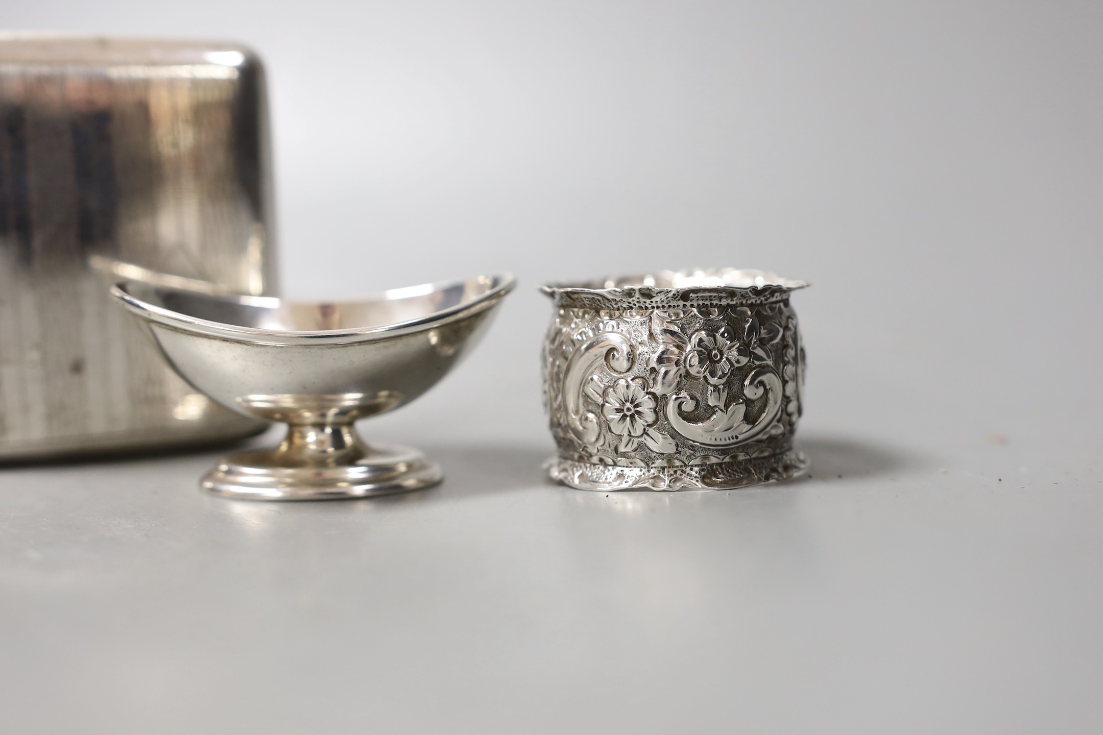 A white metal cigarette case and small silver including a pair of salts, condiment and napkin ring.
